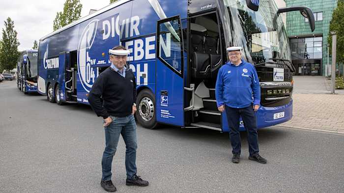Schalke bus stewards wearing plastic masks